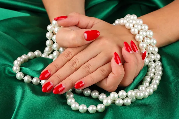 Жіночі руки тримають намистини на кольоровому фоні — стокове фото