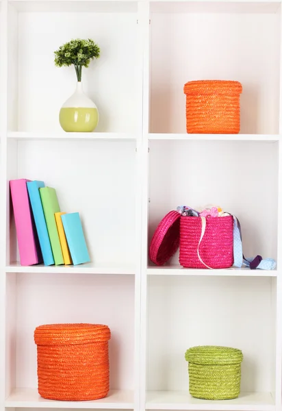 Cajas de mimbre de color en estantes del gabinete —  Fotos de Stock