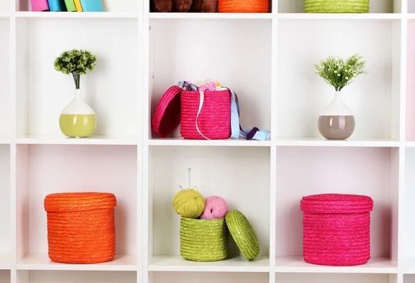 Color wicker boxes on cabinet shelves — Stock Photo, Image