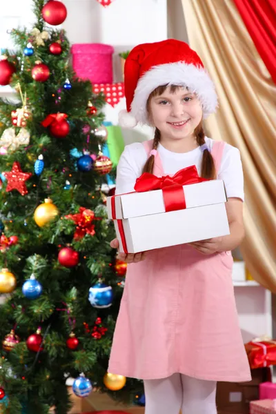 Petite fille avec des jouets de Noël dans une chambre décorée de façon festive — Photo