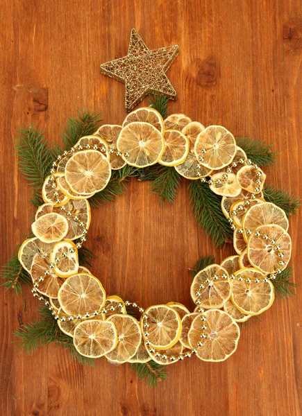 Corona de Navidad de limones secos con abeto y estrella, sobre fondo de madera —  Fotos de Stock