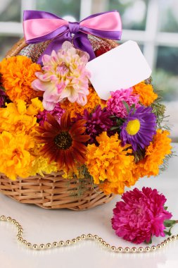 Kağıt Not penceresinin arka plan üzerinde beyaz masa üstünde sepetle parlak çiçek dolu güzel bir buket