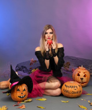 Halloween cadı ile renkli arka plan üzerinde kırmızı elma