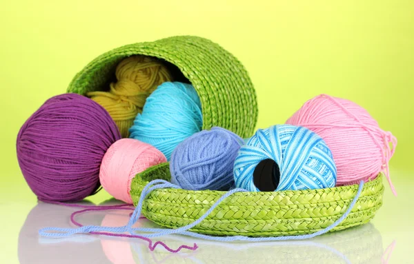 Colorful yarn for knitting in green basket on green background — Stock Photo, Image