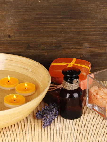 Botella con aceites aromáticos con accesorios para relajarse sobre mesa de madera sobre fondo de madera — Foto de Stock