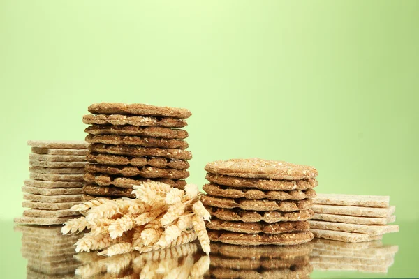 Leckeres Knäckebrot und Ohren, auf grünem Hintergrund — Stockfoto