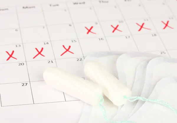 Calendario de menstruación con toallas sanitarias y tampones, primer plano — Foto de Stock