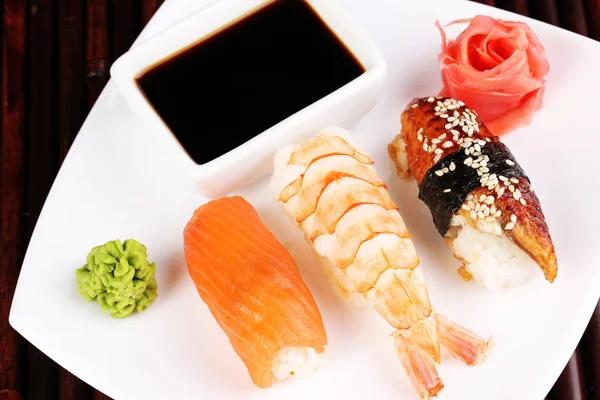 Délicieux sushi servi sur assiette sur tapis de bambou — Photo