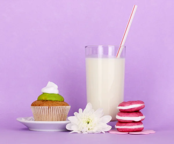 Copo de leite novo fresco com bolos no fundo roxo — Fotografia de Stock