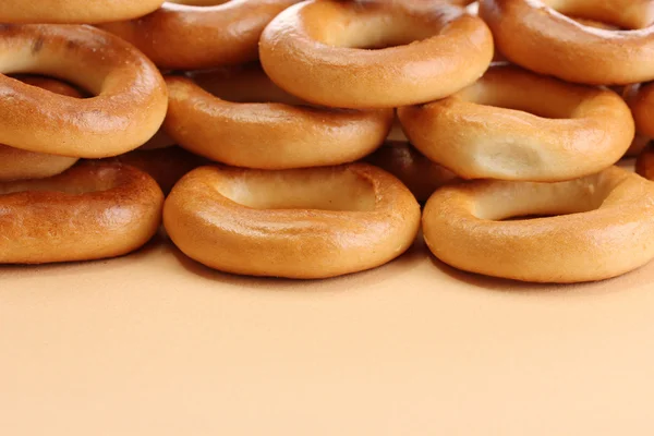 Smakelijke bagels, op beige achtergrond — Stockfoto