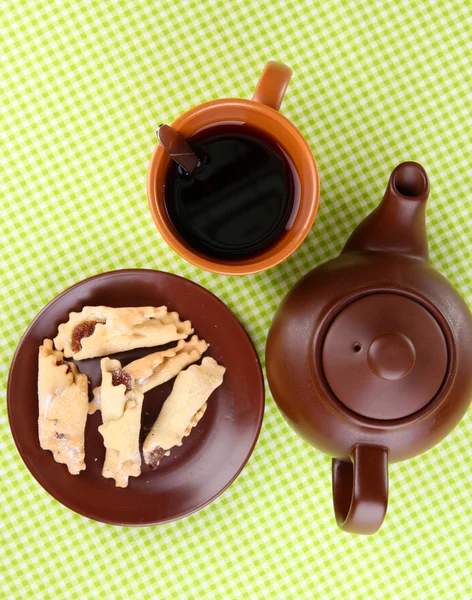 Draufsicht auf Tasse Tee und Teekanne auf grünen Tischdecken — Stockfoto