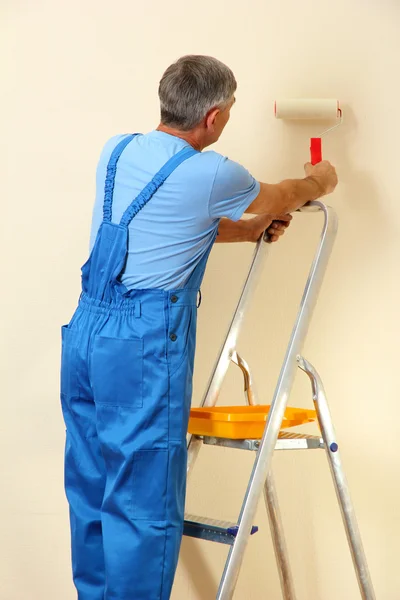 Pintor masculino pinta parede no quarto close-up — Fotografia de Stock