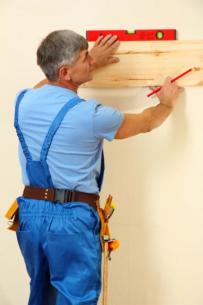 Builder mäta väggen i rummet närbild — Stockfoto