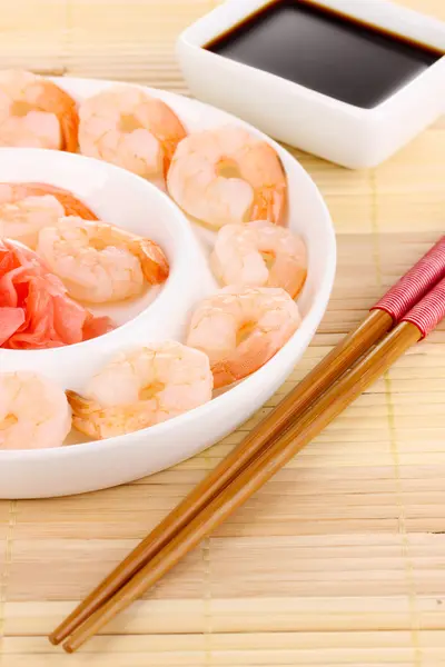 Langostinos en plato con palillos y salsa —  Fotos de Stock