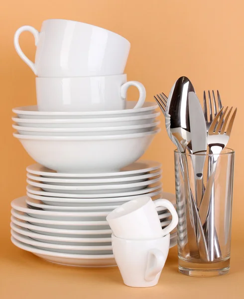 Čisté bílé nádobí na béžové pozadí — Stock fotografie