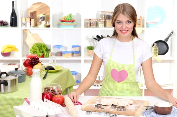 A young girl in kitchen during cooking biscuits — Stock Photo, Image