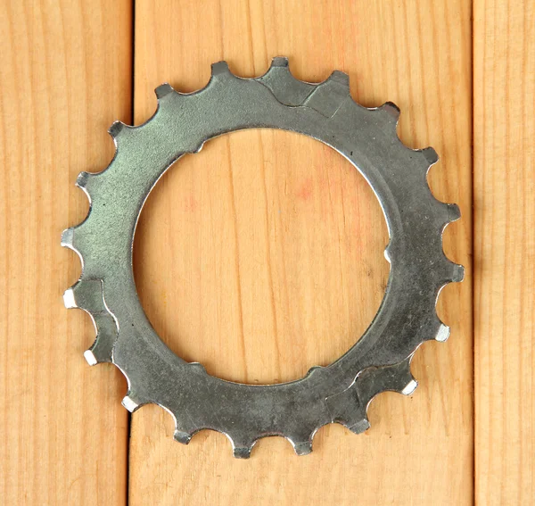 Metal cogwheel on wooden background — Stock Photo, Image