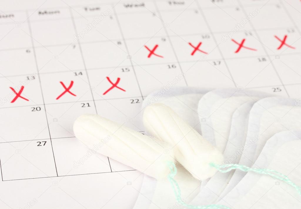 menstruation calendar with sanitary pads and tampons, close-up