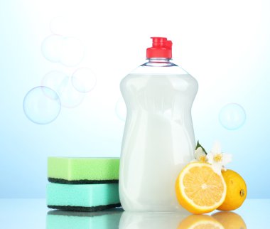 sünger ve çiçekli mavi zemin üzerine limon ile bulaşık deterjanı