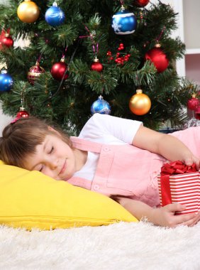 küçük kız festively bir şekilde dekore edilmiş oda ellerinde hediye ile uyuya