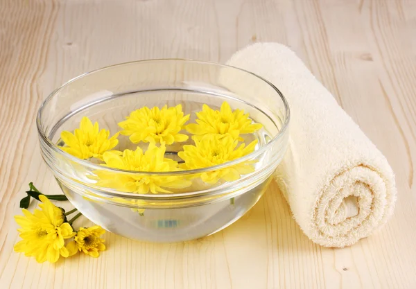 Kom met gele bloemen, spa instellen op houten achtergrond — Stockfoto