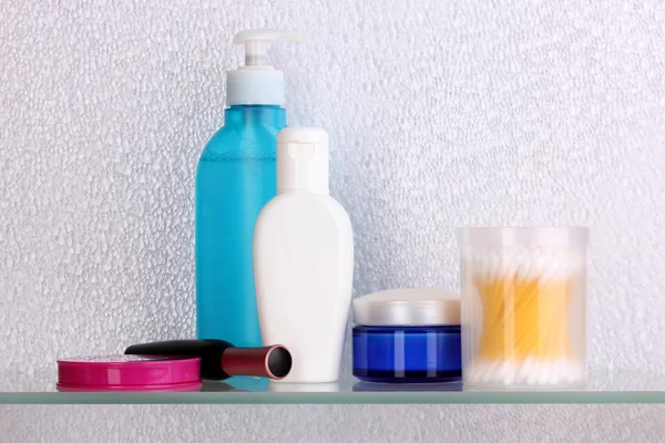 Mensola con cosmetici e articoli da toeletta in bagno — Foto Stock