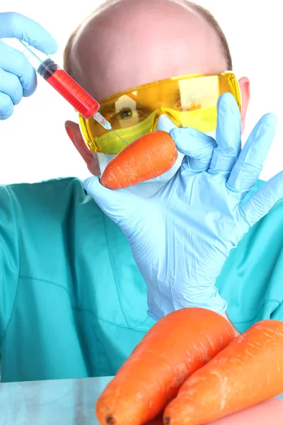 Scientist injecting GMO into the carrot — Stock Photo, Image
