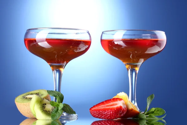 Fruit jelly in glasses and fruits on blue background — Stock Photo, Image