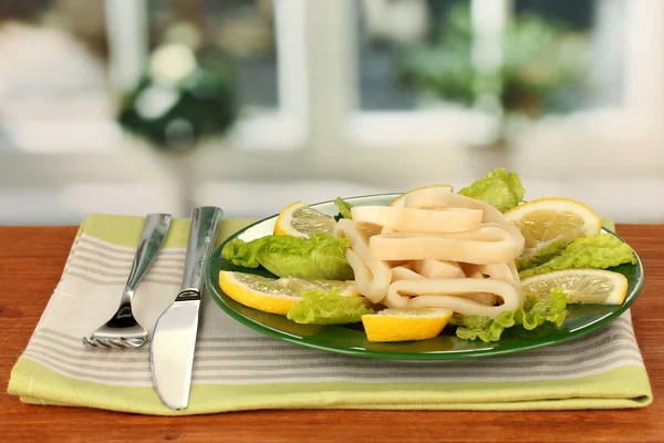 Cooked squid rings on lettuce with lemon on the plate close-up — Stock Photo, Image