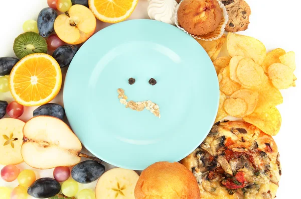 Blue plate surrounded by useful and harmful food isolated on white — Stock Photo, Image