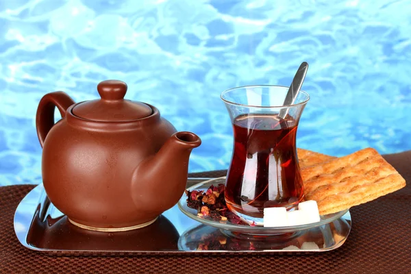 Glas Turkse thee en waterkoker op kleur achtergrond — Stockfoto
