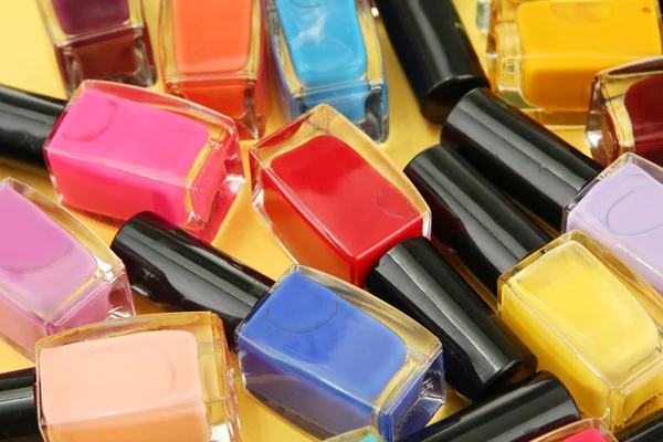 Grupo de esmaltes de uñas brillantes, sobre fondo amarillo —  Fotos de Stock