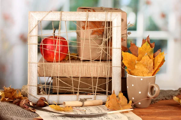 Jesienny skład z darem, książki i pozostawia na jasnym tle — Zdjęcie stockowe