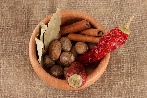 Nutmeg and other spices on sackcloth background — Stock Photo, Image