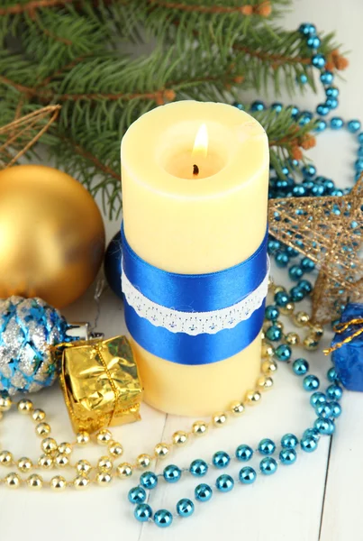 Vela amarela com decoração de Natal no fundo claro — Fotografia de Stock