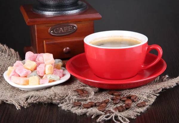 Xícara vermelha de café com delícia rahat e moinho de café na mesa de madeira — Fotografia de Stock