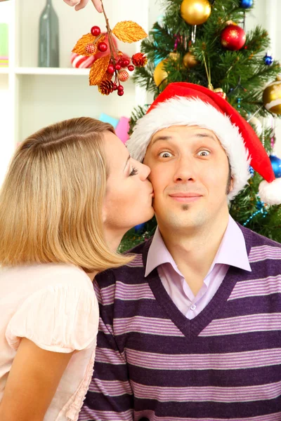 Romantic kiss under mistletoe — Stock Photo, Image