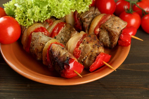 Ízletes grillezett hús és zöldség nyárson tálcán, faasztalon — Stock Fotó