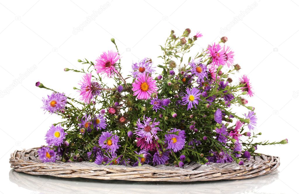 beautiful bouquet of purple flowers on wicker mat isolated on white