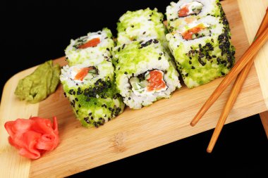 ahşap plaka üzerine siyah izole lezzetli rulo servis