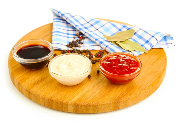 Various sauces on chopping board isolated on white — Stock Photo, Image