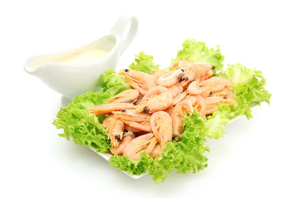 Boiled shrimps with lettuce leaves on plate and sauce, isolated on white — Stock Photo, Image