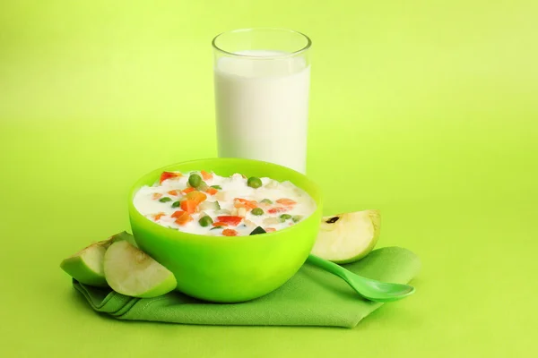 Tasty dieting food and glass of milk, on green background — Stock Photo, Image