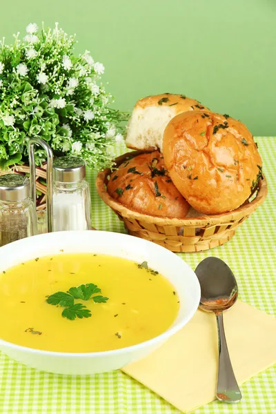 緑のテーブル クロスのクローズ アップ緑の背景に白色板の香りスープ — ストック写真