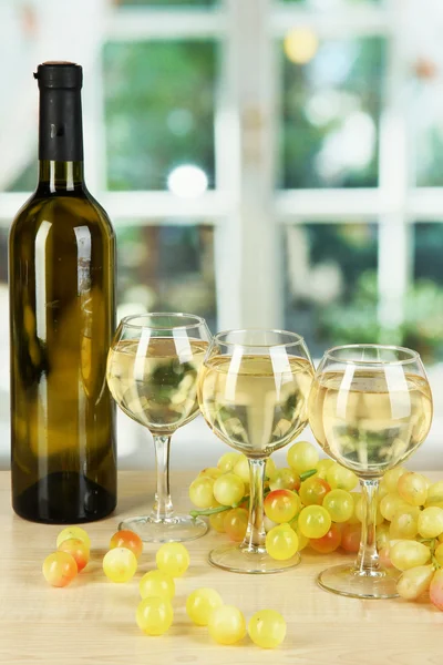 Witte wijn in glas met fles op achtergrond van venster — Stockfoto