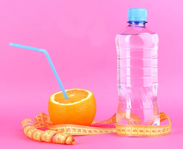 Oranges mûres et bouteille d'eau comme symbole de l'alimentation sur fond rose — Photo