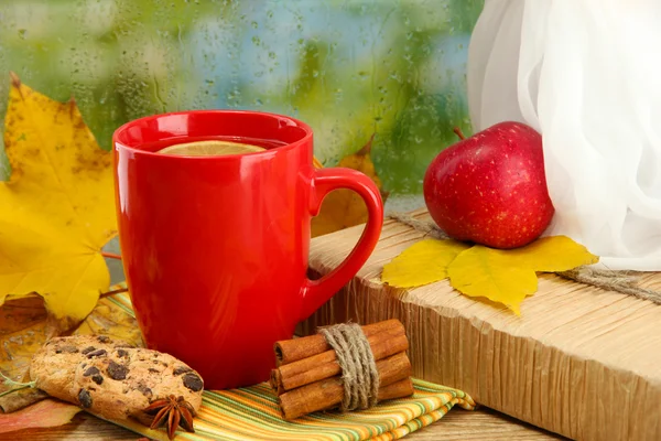 Šálek horkého čaje a podzimní listí, na pozadí déšť — Stock fotografie