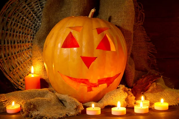 Halloween pompoen en kaarsen, op houten achtergrond — Stockfoto
