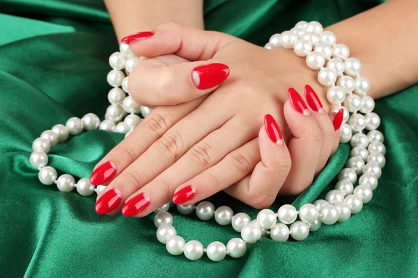 Жіночі руки тримають намистини на кольоровому фоні — стокове фото