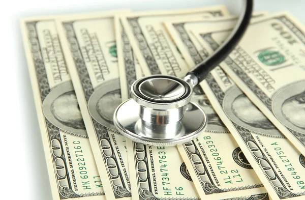 Healthcare cost concept: stethoscope and dollars isolated on white — Stock Photo, Image